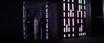 Movie still from “Star Wars: Episode IV - A New Hope” (1977), directed by George Lucas – A group of star wars characters standing in a hallway; Wide shot, Low angle
