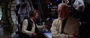 Movie still from “Star Wars: Episode IV - A New Hope” (1977), directed by George Lucas – Two people sitting at a table in a room; Medium shot, Over the shoulder angle