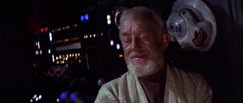 Movie still from “Star Wars: Episode IV - A New Hope” (1977), directed by George Lucas – An old man with a beard and a white robe is smiling; Close Up shot, Low angle