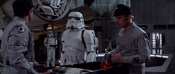 Movie still from “Star Wars: Episode IV - A New Hope” (1977), directed by George Lucas – A man standing next to a stormtrooper; Medium shot, Over the shoulder angle