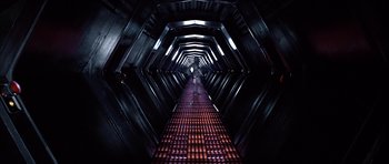 Movie still from “Star Wars: Episode IV - A New Hope” (1977), directed by George Lucas – A dark hallway with a person walking down it; Extreme Wide shot, High angle