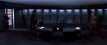 Movie still from “Star Wars: Episode IV - A New Hope” (1977), directed by George Lucas – A dark room with a darth vader in the middle of the room; Wide shot, High angle