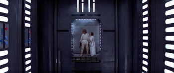 Movie still from “Star Wars: Episode IV - A New Hope” (1977), directed by George Lucas – A couple of people standing next to each other in a building; Wide shot, Low angle