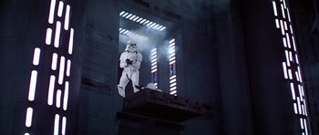 Movie still from “Star Wars: Episode IV - A New Hope” (1977), directed by George Lucas – A star wars character on display in a building; Wide shot, Low angle