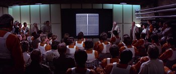 Movie still from “Star Wars: Episode IV - A New Hope” (1977), directed by George Lucas – A group of people sitting in front of a projector screen; Extreme Wide shot, High angle