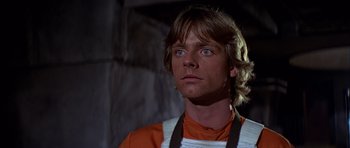 Movie still from “Star Wars: Episode IV - A New Hope” (1977), directed by George Lucas – A man in an orange and white shirt looking to his left; Close Up shot, Low angle