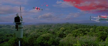 Movie still from “Star Wars: Episode IV - A New Hope” (1977), directed by George Lucas – A group of planes flying over a lush green forest; Extreme Wide shot, Low angle