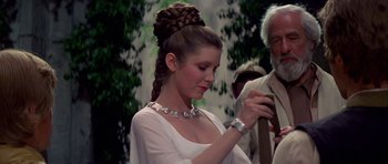 Movie still from “Star Wars: Episode IV - A New Hope” (1977), directed by George Lucas – A woman in a white dress holding onto a tie; Medium shot, Over the shoulder angle
