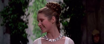 Movie still from “Star Wars: Episode IV - A New Hope” (1977), directed by George Lucas – A woman with a silver necklace in her hair; Close Up shot, Over the shoulder angle