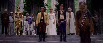 Movie still from “Star Wars: Episode IV - A New Hope” (1977), directed by George Lucas – A group of people standing on steps in front of trees; Wide shot, Low angle
