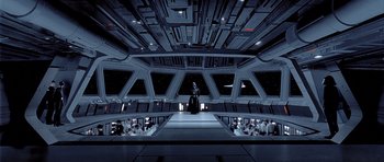 Movie still from “Star Wars: Episode V - The Empire Strikes Back” (1980), directed by Irvin Kershner – A man standing on a stage in a spaceship; Wide shot, High angle