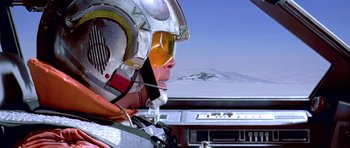 Movie still from “Star Wars: Episode V - The Empire Strikes Back” (1980), directed by Irvin Kershner – A man in a fighter pilot's helmet looking out the window of an airplane; Medium shot, Low angle