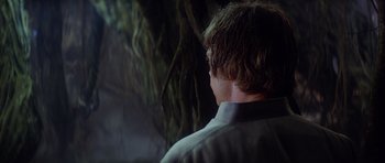 Movie still from “Star Wars: Episode V - The Empire Strikes Back” (1980), directed by Irvin Kershner – A young man is standing in front of a tree; Close Up shot, Over the shoulder angle