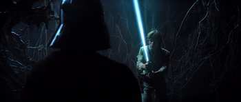 Movie still from “Star Wars: Episode V - The Empire Strikes Back” (1980), directed by Irvin Kershner – A man holding a light saber while standing next to another man; Medium shot, Over the shoulder angle