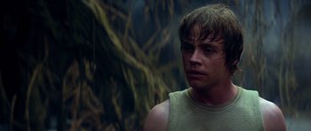 Movie still from “Star Wars: Episode V - The Empire Strikes Back” (1980), directed by Irvin Kershner – A young man with wet hair is standing in front of a tree; Close Up shot, Over the shoulder angle