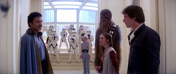 Movie still from “Star Wars: Episode V - The Empire Strikes Back” (1980), directed by Irvin Kershner – A group of star wars characters standing in front of a building; Wide shot, Over the shoulder angle