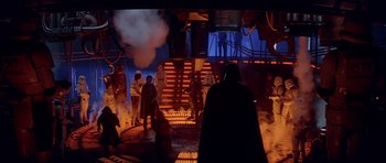 Movie still from “Star Wars: Episode V - The Empire Strikes Back” (1980), directed by Irvin Kershner – A group of people standing around in a room; Wide shot, Over the shoulder angle