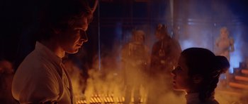 Movie still from “Star Wars: Episode V - The Empire Strikes Back” (1980), directed by Irvin Kershner – A group of people standing around a fire pit; Close Up shot, Over the shoulder angle
