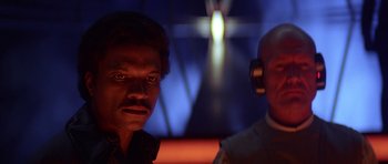 Movie still from “Star Wars: Episode V - The Empire Strikes Back” (1980), directed by Irvin Kershner – A man and a man with headphones in front of a wall; Close Up shot, Low angle