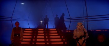 Movie still from “Star Wars: Episode V - The Empire Strikes Back” (1980), directed by Irvin Kershner – A group of people walking up stairs in a dark room; Wide shot, Low angle