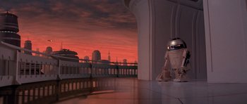 Movie still from “Star Wars: Episode V - The Empire Strikes Back” (1980), directed by Irvin Kershner – An image of a robot in a room with a city in the background; Extreme Wide shot, Low angle