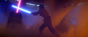 Movie still from “Star Wars: Episode V - The Empire Strikes Back” (1980), directed by Irvin Kershner – A man holding a light saber in a dark room; Wide shot, Low angle