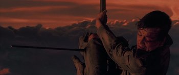 Movie still from “Star Wars: Episode V - The Empire Strikes Back” (1980), directed by Irvin Kershner – A person holding onto a pole in front of a red sky; Wide shot, Low angle