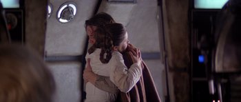 Movie still from “Star Wars: Episode V - The Empire Strikes Back” (1980), directed by Irvin Kershner – Two people hugging each other while one of them is wrapped in a blanket; Medium shot, Low angle