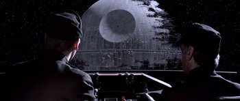 Movie still from “Star Wars: Episode VI - Return of the Jedi” (1983), directed by Richard Marquand – A man is looking at a star wars scene; Medium shot, Low angle