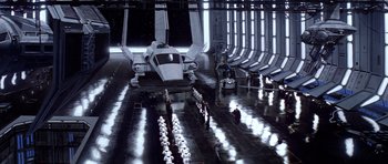 Movie still from “Star Wars: Episode VI - Return of the Jedi” (1983), directed by Richard Marquand – A group of people standing next to an airplane in a hangar; Extreme Wide shot, High angle
