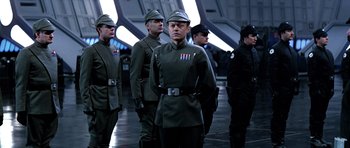 Movie still from “Star Wars: Episode VI - Return of the Jedi” (1983), directed by Richard Marquand – A group of men in uniform standing next to each other; Medium shot, Over the shoulder angle