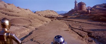 Movie still from “Star Wars: Episode VI - Return of the Jedi” (1983), directed by Richard Marquand – An r 2 d 2 is sitting in the middle of the desert; Extreme Wide shot, High angle
