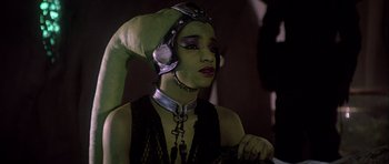 Movie still from “Star Wars: Episode VI - Return of the Jedi” (1983), directed by Richard Marquand – A woman with green skin wearing a helmet; Close Up shot, Over the shoulder angle