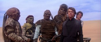 Movie still from “Star Wars: Episode VI - Return of the Jedi” (1983), directed by Richard Marquand – A group of star wars characters standing next to each other; Medium shot, Low angle