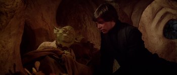 Movie still from “Star Wars: Episode VI - Return of the Jedi” (1983), directed by Richard Marquand – A young man looking at an old man in a cave; Medium shot, Over the shoulder angle