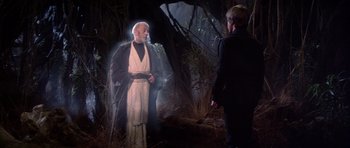 Movie still from “Star Wars: Episode VI - Return of the Jedi” (1983), directed by Richard Marquand – A man in a robe and a man in a black shirt are in the woods; Medium shot, Over the shoulder angle