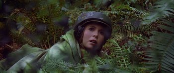Movie still from “Star Wars: Episode VI - Return of the Jedi” (1983), directed by Richard Marquand – A woman wearing a helmet in the woods; Close Up shot, Low angle