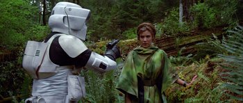 Movie still from “Star Wars: Episode VI - Return of the Jedi” (1983), directed by Richard Marquand – A woman in a green robe holding a gun in her hand; Medium shot, Over the shoulder angle