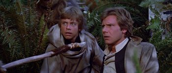 Movie still from “Star Wars: Episode VI - Return of the Jedi” (1983), directed by Richard Marquand – Two people in a forest , one of which is holding a stick; Close Up shot, Low angle