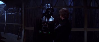 Movie still from “Star Wars: Episode VI - Return of the Jedi” (1983), directed by Richard Marquand – A young boy standing next to a darth vader costume; Medium shot, Over the shoulder angle