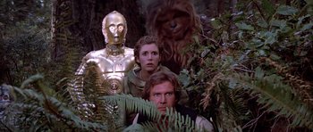 Movie still from “Star Wars: Episode VI - Return of the Jedi” (1983), directed by Richard Marquand – A group of star wars characters standing in the woods; Wide shot, Low angle