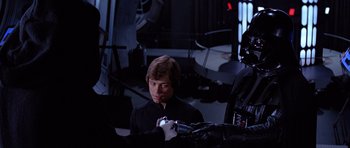 Movie still from “Star Wars: Episode VI - Return of the Jedi” (1983), directed by Richard Marquand – A young man holding a remote control in his hand; Medium shot, Over the shoulder angle