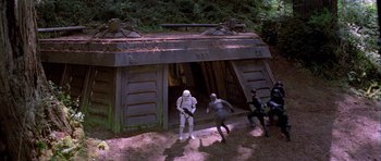 Movie still from “Star Wars: Episode VI - Return of the Jedi” (1983), directed by Richard Marquand – A group of people are standing in front of a building; Wide shot, High angle