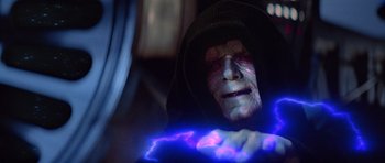 Movie still from “Star Wars: Episode VI - Return of the Jedi” (1983), directed by Richard Marquand – An image of an evil looking man with a blue light coming out of his hand; Close Up shot, Over the shoulder angle