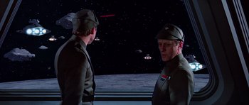 Movie still from “Star Wars: Episode VI - Return of the Jedi” (1983), directed by Richard Marquand – Two men in military fatigues are looking at each other; Medium shot, Over the shoulder angle