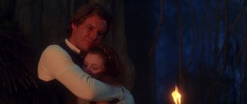 Movie still from “Star Wars: Episode VI - Return of the Jedi” (1983), directed by Richard Marquand – A man and a woman hugging in front of a fire; Medium shot, Low angle