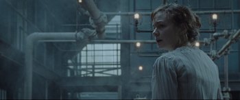 Movie still from “Suffragette” (2015), directed by Sarah Gavron – A man standing next to pipes in an industrial setting; Medium shot, Low angle