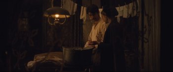 Movie still from “Suffragette” (2015), directed by Sarah Gavron – A man and a woman standing next to each other in front of a pot; Medium shot, Over the shoulder angle