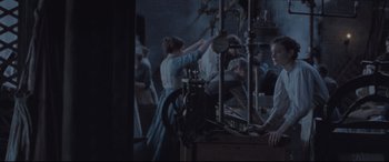 Movie still from “Suffragette” (2015), directed by Sarah Gavron – A group of people gathered in a room; Medium shot, Over the shoulder angle