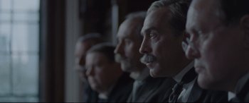 Movie still from “Suffragette” (2015), directed by Sarah Gavron – A group of men sitting next to each other in a room; Close Up shot, Low angle